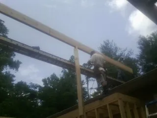 Carpenter setting a ridge beam over a new addition frame — Ice Dam Removal by Roofing Brothers in Duffield