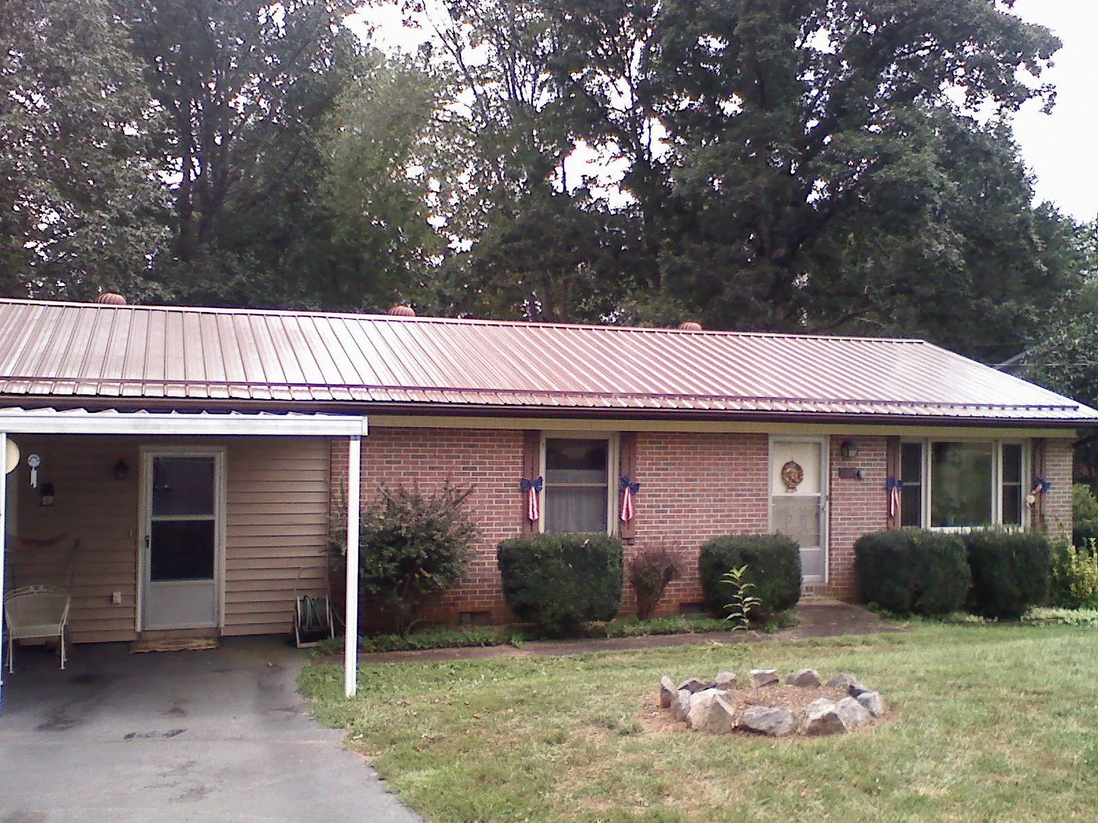 Bronze metal roof and carport on a brick ranch home — Roof Repair work by our crew in Duffield