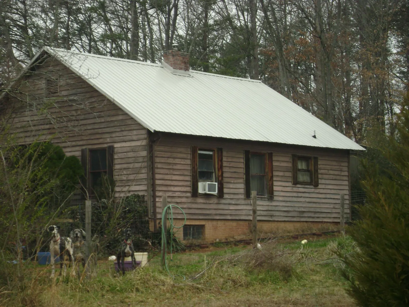 White metal roof on an old wood sided farmhouse, from a Metal Roof Installation job in Duffield